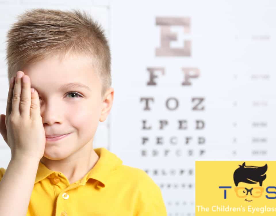 kid holding eye with hand with a blurred out eye exam behind him.